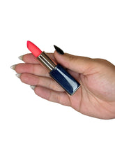 Hand holding a red lipstick discrete vibrator with a blue case on a white background