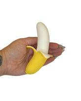 Hand holding a yellow banana-shaped object against a white background
