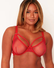 Woman wearing a red strappy bra against a white background