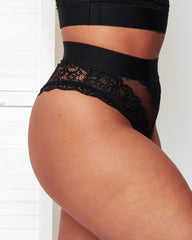 Detailed front view of the Francine Thong in Black by Tutti Rouge, showcasing intricate lace edging, sheer mesh detailing, and a smooth supportive waistband for a contemporary lingerie look.