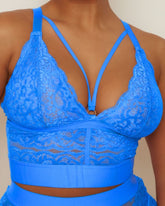 Blue lace bralette worn by a person against a neutral background