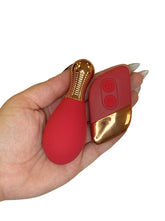 Red and gold object held in a hand on a white background