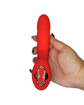 Red toy with a gold emblem held by a hand on a white background