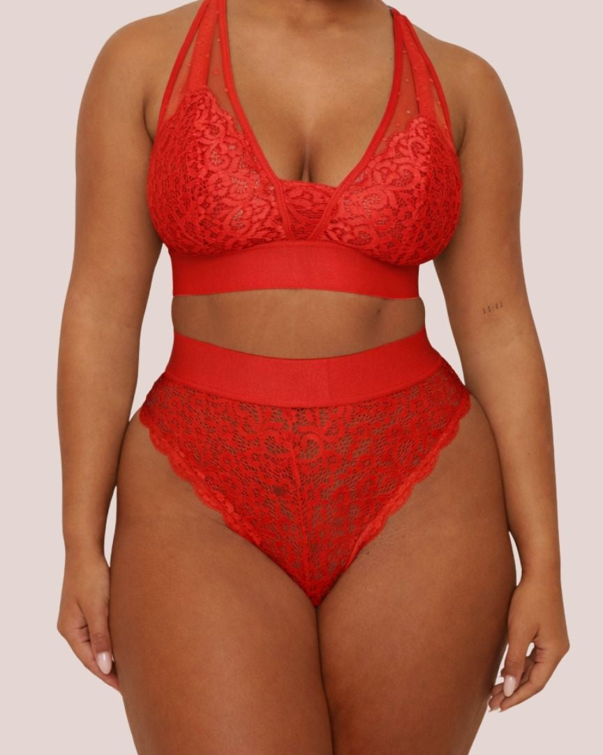Model wearing the Hallie Bralette and Brazilian Brief Set in Chilli Pepper Red from Tutti Rouge. The set features a supportive lace bralette with sheer mesh panels and matching high-waisted Brazilian briefs.