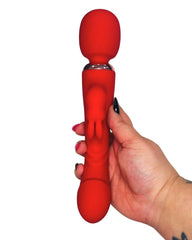 Red silicone wand massager held by a hand on a white background