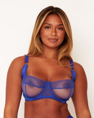 Woman wearing a blue bra against a white background