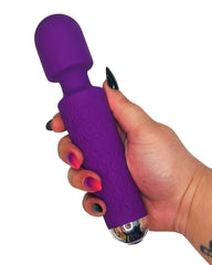 Purple toy held in a hand with a white background
