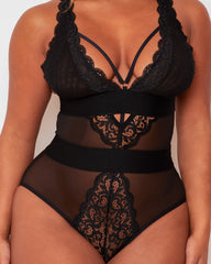 Model posing in the Alicia Bodysuit in Black by Tutti Rouge, displaying sheer mesh panels, intricate lace detailing, and a supportive, figure-enhancing fit.