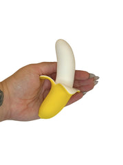 Hand holding a yellow banana-shaped object against a white background
