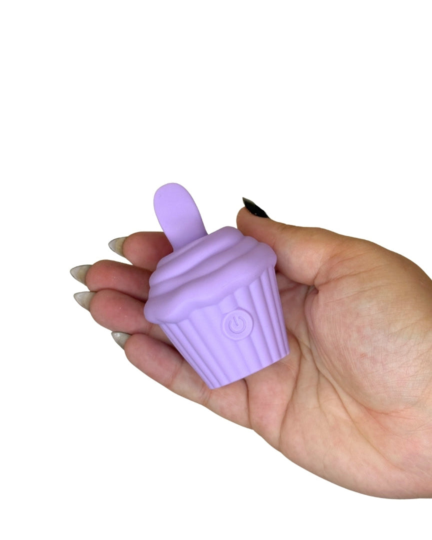 Hand holding a purple silicone cupcake-shaped item against a white background