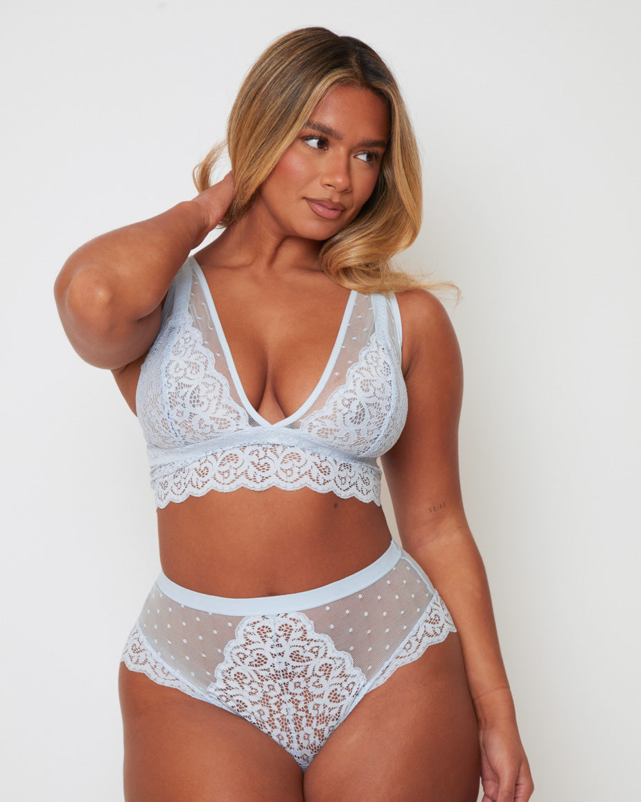 Close-up of the Eva Bralette and Brief set in Ballad Blue, showcasing floral lace cups, sheer polka-dot mesh inserts, scalloped lace trims, and soft pastel styling for a romantic finish.