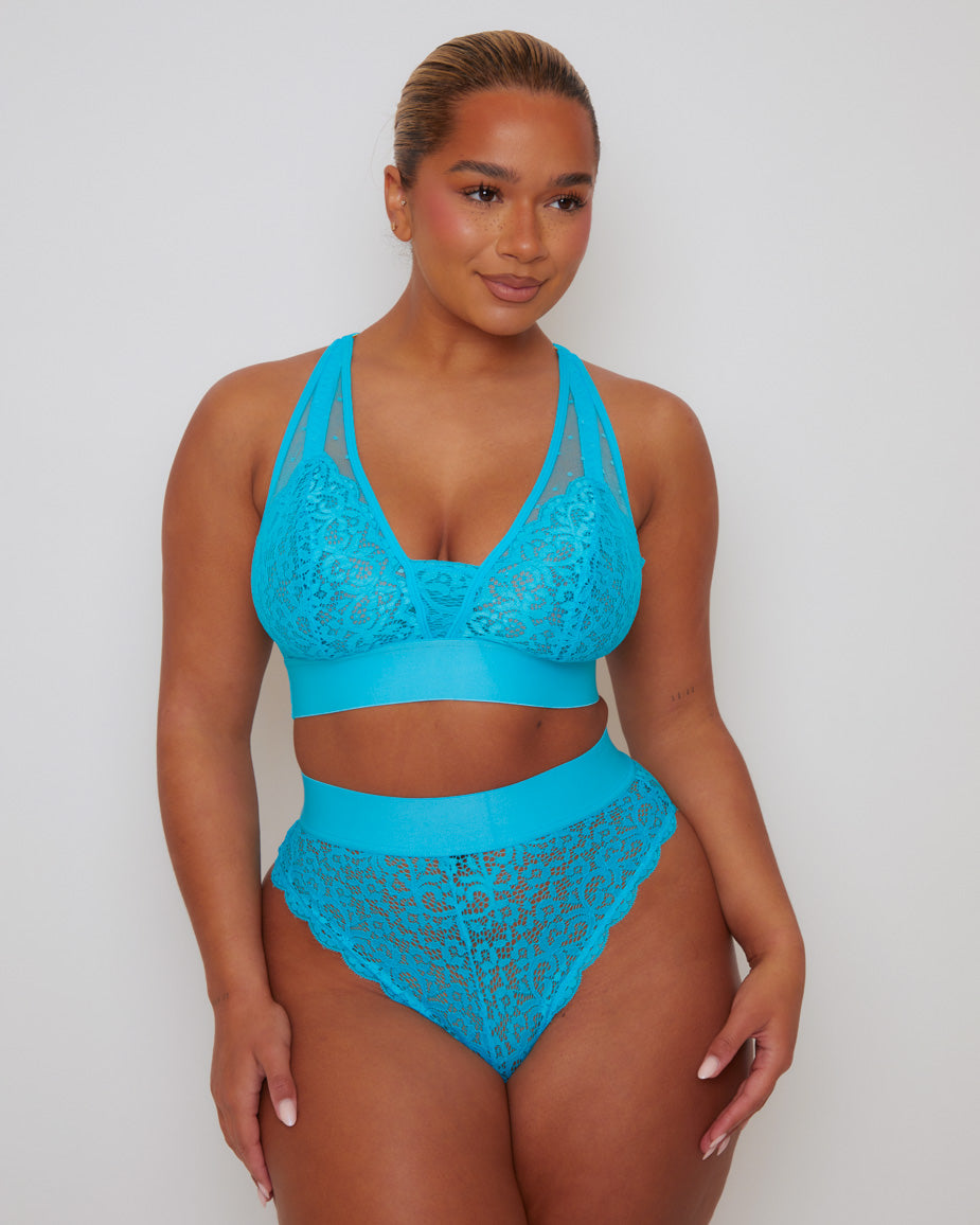 Front view of a model wearing the Hallie Bralette and Brief in Bluebird Blue, featuring floral stretch lace, sheer mesh accents, a supportive wide underband, and a high-waisted lace brief with scalloped edges.