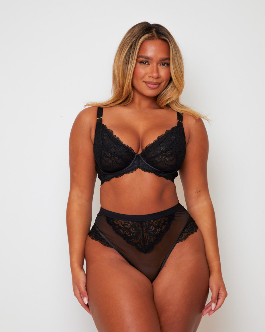 Model wearing the Tutti Rouge Harlow Fuller Bust Bra and High Waist Brief Set in Midnight Black with delicate floral lace, sheer mesh and supportive fuller bust fit.