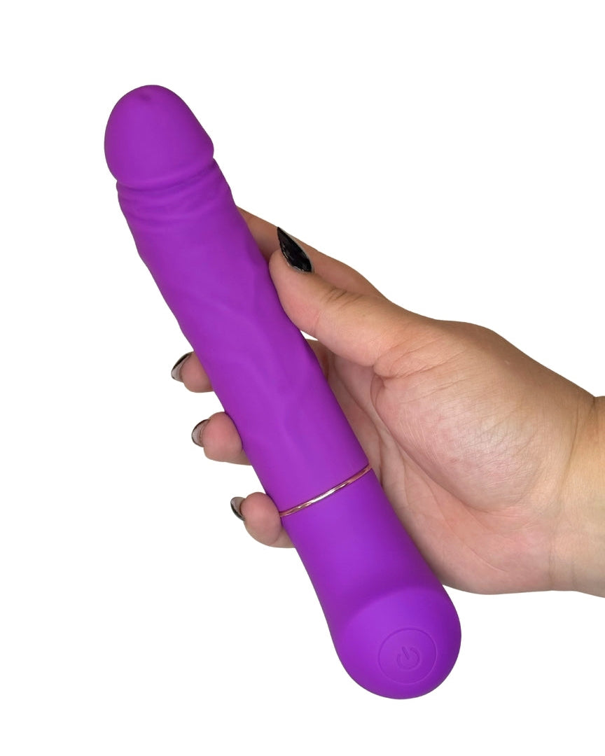 Purple toy held in a hand against a white background