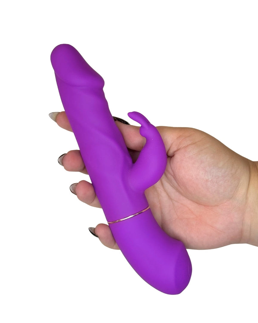 Hand holding a purple toy against a white background