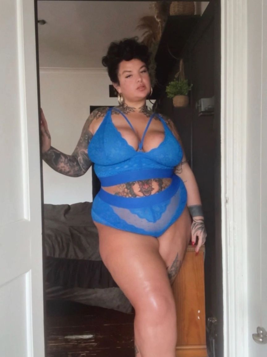 Person wearing a blue lingerie set standing in a doorway.