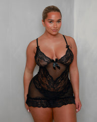 Lifestyle front view of the Tutti Boudoir Vanta Babydoll in Black, highlighting the delicate lace cups, sheer mesh panels, satin bow detail and lightweight, confidence-boosting fit.